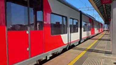 Şehirdeki tren istasyonunda yüksek hızla geçen banliyö elektrik treni.