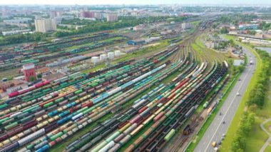 Şehir manzarasının arka planına karşı bir çok yük treni olan büyük bir marşallama tren istasyonunun panoramik hava görüntüsü