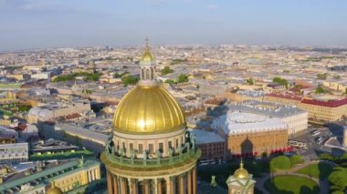 Aerial view of the dome of St. Isaac's Cathedral and the historic part of the city of St. Petersburg and the reflected golden evening sunlight