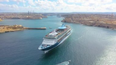 Cruise liner ship in ocean floats out of the historic bay. Aerial top view