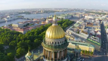 Aerial view of the dome of St. Isaac's Cathedral and the historic part of the city of St. Petersburg and the reflected golden evening sunlight