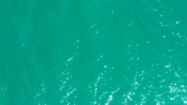 Iridescent tropical warm water lit by the sun rays of light glare in the water
