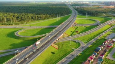 Otoyol kavşağının havadan görünüşü. Çayırların ve ormanın çevresindeki varoşlarda yol kavşağı