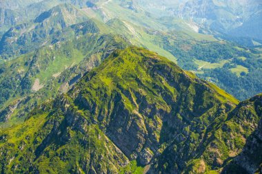 View from a height on the slopes of the mountains of the pass ridge covered with vegetation, a beautiful natural landscape