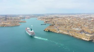 Cruise liner ship in ocean floats out of the historic bay. Aerial top view