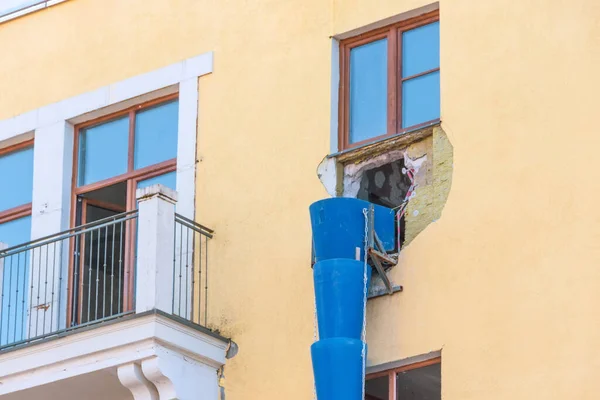Pipe for debris, waste tube. Blue telescope rubble chute. Plastic garbage chute fixed on facade. Repair in apartment, office of old historical building. Disposal of construction waste from height