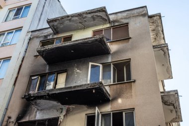 Yangından sonra apartman dairesi, ıslak pencereler ve siyah dumandan balkonlar. Terk edilmiş ev, tahliye, tahliye.