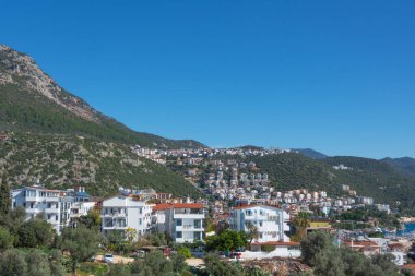 Türkiye 'nin sahil beldesi Kas' ın görkemli panoramik manzarası. Kentte geleneksel evleri, kırmızı çatıları olan villaları ve otelleri turistler için açık olan tepe tarafı.
