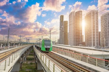 Banliyö yolcu taşımacılığı, modern bir şehirde gökdelenler arasında metro.