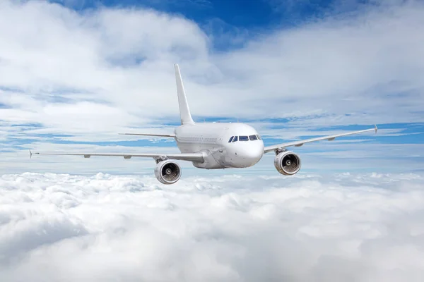 白い飛行機は上の雲の端に沿って飛ぶ — ストック写真