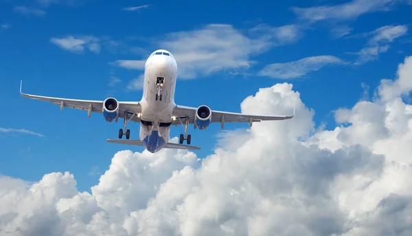 空と雲の背景に延長された着陸装置で離陸する飛行機 — ストック写真
