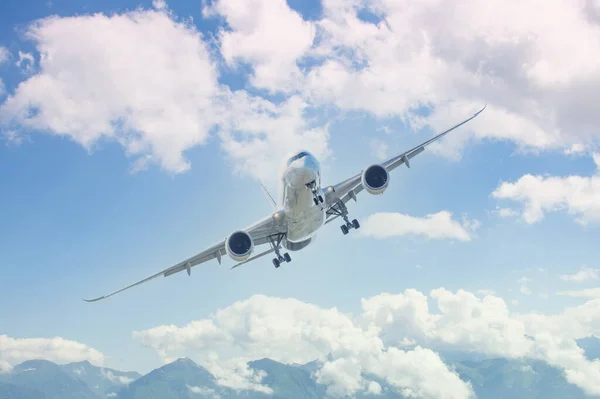 絵のように美しい山々を背景に 空中を回転する長距離着陸装置を有する航空機の着陸進入 — ストック写真
