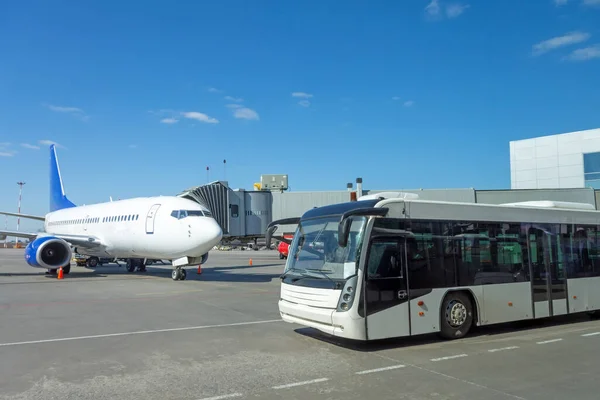 出発手続中にターミナルビルから航空機のランプに人々を輸送するための白い旅客バス — ストック写真