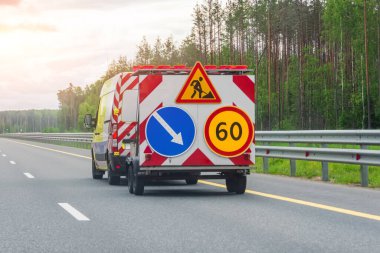 Karavan ve hız limiti ve yol bakım uyarı levhalarına sahip yol servis aracı
