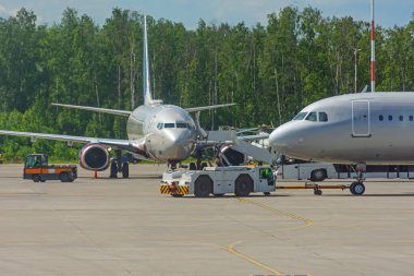 Merdiven merdiveni olan bir uçak arka planda yolcu bekliyor.