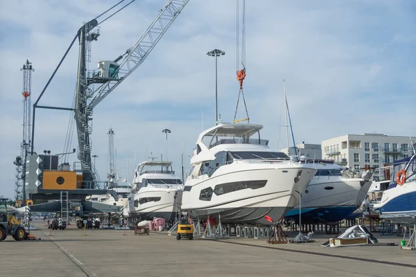 stock image Sea port cargo cranes wheels supports for lifting marine vessels and offshore storage installations on land, servicing yachts, boats other ships in docks pier. Freight industry, maritime transport