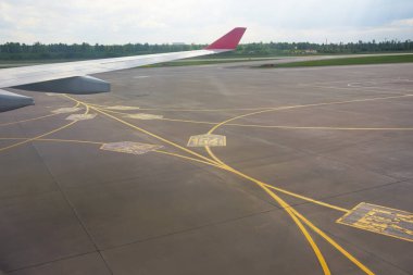 Havalimanı sarı taksi yolu. Beton asfalttaki apronda işaretler var. Uçak pilotları için imza.