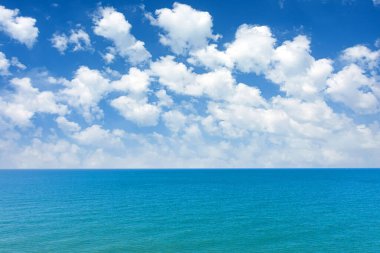 Deniz yüzeyi ve ufuk manzarası. Tropikal enlemlerde okyanus üzerinde yaz kabarık bulutları. Yaz tatili kavramı, seyahat