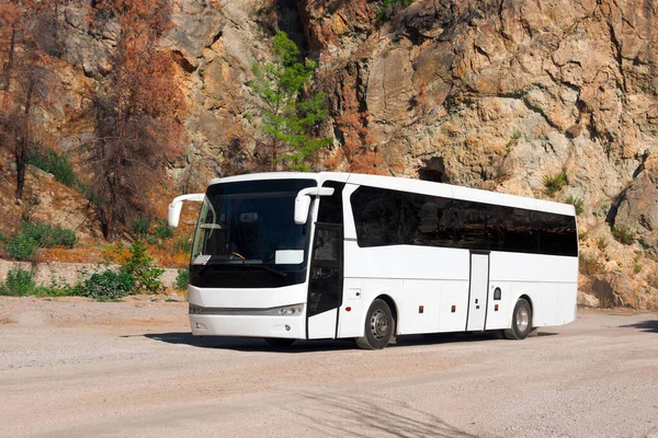 在峡谷岩石背景下的白色旅游巴士 — 图库照片