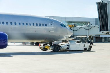 Operasyon sırasında ticari yolcu uçağı. Hava köprüsünden ayrılırken yolcu gemisinin parlak metal gövdesi.