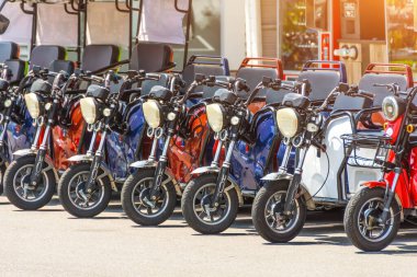 Elektrikli scooterlar, üç koltuklu motosikletler kiralık ve şehirde dolaşmak için park yeri.