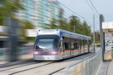 Şehrin caddelerinde modern konforlu tramvay hareket ediyor, elektrikli ulaşım.