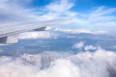 Güzel bir gökyüzü ve dağlarla kanat çırpışları sırasında pencereden uçakları seyrediyorum.