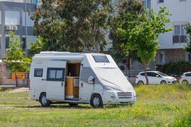 Şehir parkının çayırında park etmiş gezici bir minibüs.