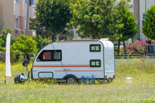 Mobile home trailer on wheels van parked in the street on the meadow of the city park