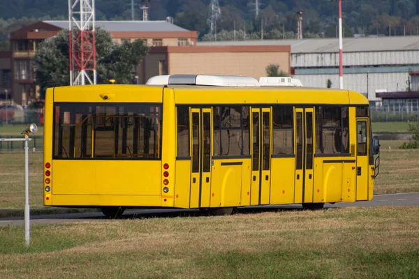 노란색 버스를 공항에 사람들을 비행기로 나른다 — 스톡 사진