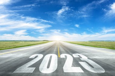 2023 numaralar gün batımında asfalt yolun ortasında yazılmış. Planlama ve görev kavramı, iş stratejisi, fırsatlar, umut, yeni yaşam değişimi sembolü