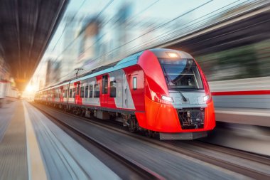 Elektrikli yolcu treni şehir manzarası arasında yüksek hızda yol alır