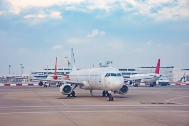 Kirli yolcu jet uçağı arka plan terminaline karşı kalkış için piste gidiyor.