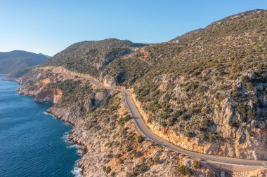 Dağ yılanının üzerindeki bir dronun görüntüsü. Dağ yolunda giden araçların hava görüntüsü. Akdeniz kıyısındaki tatil köyü plajı.