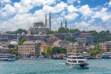 İstanbul 'un eski binaları ve bir tepede büyük bir camii, Boğaz' da yüzen insanlarla dolu gemi ve feribot ile merkezi tarihi bölümünü görmek