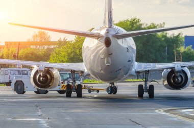 Uçak, geri çekilme operasyonunu havaalanında gerçekleştiriyor. Akşamüstü havalanmadan önce uçuşlar için uçak servisi.