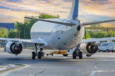 Uçak, geri çekilme operasyonunu havaalanında gerçekleştiriyor. Akşamüstü havalanmadan önce uçuşlar için uçak servisi..