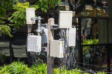 Gruplar arası iletişim kulesi telefon direği kablosuz teknoloji sinyali ve elektrik kablosu karışıklığı. Telekomünikasyon kulesi 4G ve 5G hücresel. Antenler kente monte edildi.