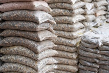 Bahçe dükkanında satılan kum torbaları, bahçe dekorasyonu için çakıl taşları. Çevre düzenlemesi için çeşitli kesirlerin ve mineral kaynaklarının taşları.