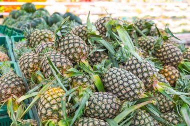 Markette içinde taze ananas olan raflar. Organik çiftliklerden gelen egzotik meyveler. Piyasa alıcılarında meyve ticareti