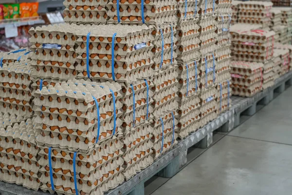 Many stacks of rows and paper packaging for chicken eggs, stacked in a store, brought from poultry farms in rural areas for sale in city stores.