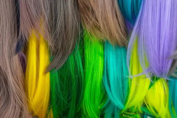 Hair samples of different colors palette. Different hair bright rich tint colors - green, yellow, turquoise. Various hair colors set background close up view. Extension equipment of natural