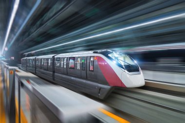 Parlak farlı modern yüksek hızlı tek raylı tren istasyondan geçiyor.