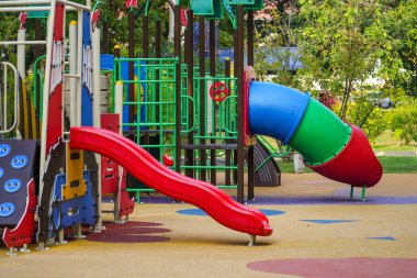 Çocuklar şehir parkında oyun alanı kaydırağıyla oynuyorlar.