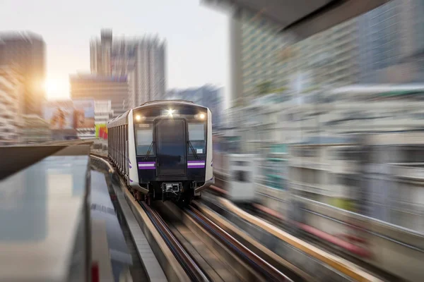 Metro treni şehirdeki yolcu platformuna doğru hızla hareket eder ve gökdelen inşa eder. Modern konforlu hızlı yolcu taşımacılığı kavramı.