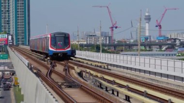 Bangkok ufuk çizgisi ve BTS gökdeleni BTS hava treni ile gökdelen istasyonu boyunca ilerliyor. 22 Aralık 2023.