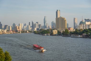 Tekne trafiği ve turist Chao Phraya 'da nehir turuna çıkıyor. Gökdelen manzaralı. Gün batımı zamanı. Bangkok, Tayland