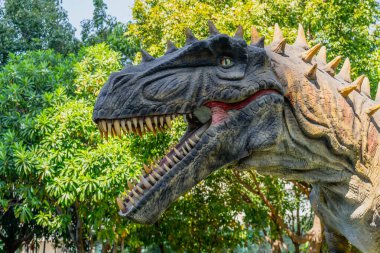 Yeşil ormandaki kızgın bir yırtıcı dinozor ormanda çığlık atıyor ve homurdanıyor.