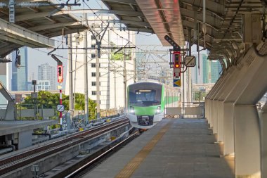 Yüksek hızlı banliyö yolcu treni istasyona geliyor. Bölgede modern konforlu hızlı yolcu taşımacılığı kavramı.
