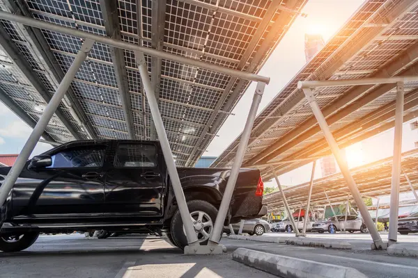Car parking with canopy roof with solar panels. Solar power generation. Black pickup car with body.
